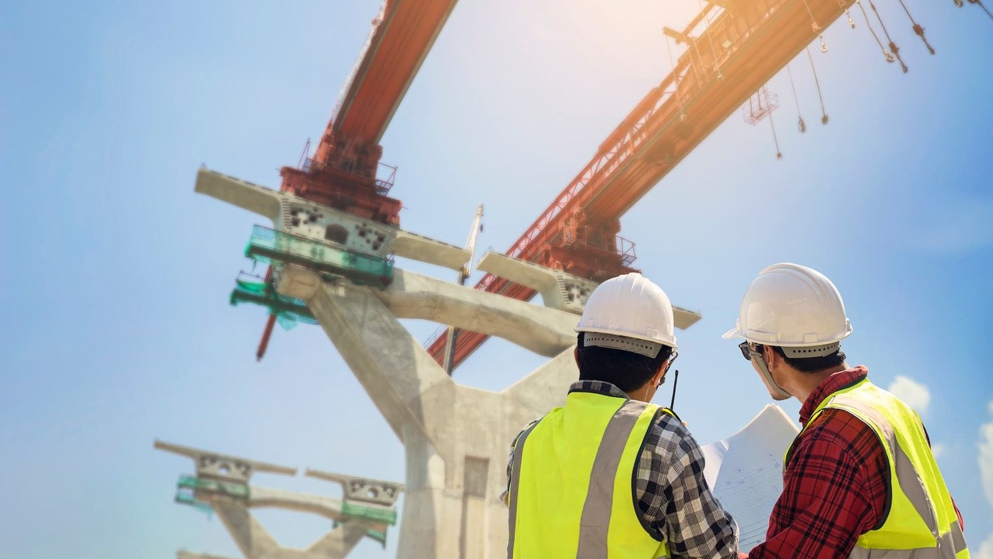 Two construction superintendents looking up at bridge crane lift