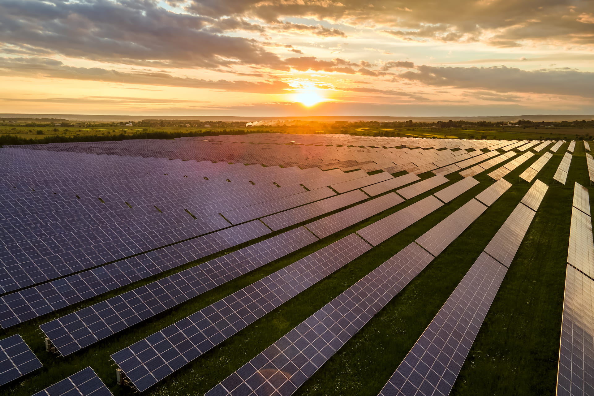 Aerial view of solar farm at sunset with dramatic clouds
