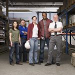 A group of people standing in a warehouse.