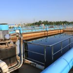 A large blue tank in the middle of an industrial area.