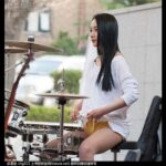 Woman playing drums outdoors.