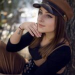 Woman in brown cap, outdoors.