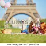 Two girls picnic Eiffel Tower balloons.