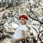 Woman in red beret, white shirt, jeans.