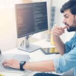 Programmer working on code at his desk.